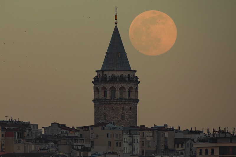The full moon rises behind Istanbul's iconic Galata Tower, Monday, April 26, 2021. (AP Photo/Emrah Gurel)