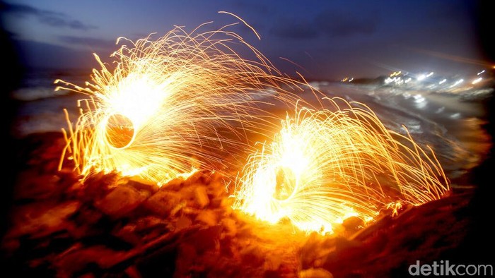 A man swings fireworks during the Muslim holy fasting month of Ramadan, on the beach of Gaza City, Monday, April 26, 2021. (AP Photo/Hatem Moussa)