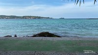 Biru langit dan laut yang bersinergi di antara horizontal daratan utama Pulau Bokori.