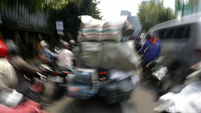Bahaya! Pemotor Nekat Bawa Barang Overload Seorang pemotor melintas dengan membawa barang berlebih di Jalan Gatot Soebroto, Jakarta, Kamis (29/04/2021). Hal ini sangat membahayakan.