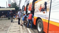 Pantauan detikcom di Jalan Raya Jakarta-Bogor pada Kamis (29/4/2021) sekitar pukul 13:00 WIB, belasan pemudik nampak tengah menunggu bus yang akan membawa mereka ke kampung halamannya masing-masing.  