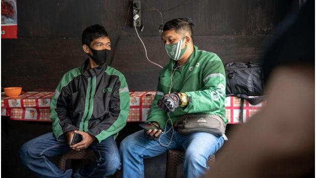Mitra pengantaran GrabFood sedang menunggu makanan di salah satu merchant di Jayapura. Layanan GrabFood membuka kesempatan kerja bagi merchant maupun mitra pengantaran.