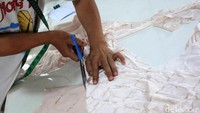 Tampak seorang pekerja tengah memotong bahan.