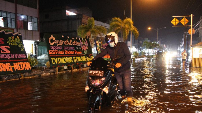 Seorang warga menyelamatkan barang-barang miliknya saat banjir besar pasang air laut (rob) di Kota Dumai, Riau, Rabu (28/4/2021). Sudah empat hari Kota Dumai dikepung banjir rob di waktu pagi dan menjelang malam hari yang mengganggu aktivitas warga. ANTARA FOTO/Aswaddy Hamid/aww.