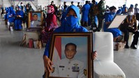 Keluarga korban tenggelamnya KRI Nanggala 402 memegang foto prajurit KRI Nanggala-402 yang gugur saat Penganugerahan tanda kehormatan dan kenaikan pangkat luar biasa prajurit KRI Nanggala-402 di Pusat Penerbangan TNI Angkatan Laut, Sidoarjo.