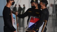 Prajurit Kapal Selam TNI AL memegang foto prajurit KRI Nanggala-402 yang gugur saat Penganugerahan tanda kehormatan dan kenaikan pangkat luar biasa prajurit KRI Nanggala-402 di Hanggar Lanudal Juanda Surabaya di Sidoarjo, Jawa Timur, Kamis (29/4/2021).