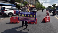 Anggota polisi memasang plang saat simulasi persiapan penyekatan larangan mudik di kawasan jalur Terminal Mengwi, Badung, Bali, Rabu (28/4/2021). ANTARA FOTO/Nyoman Hendra Wibowo
