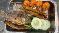 Semua lauk di sini disajikan di nampan stainless besar. Lengkap dengan lalapan mentimun dan kacang panjang. Foto: detikfood