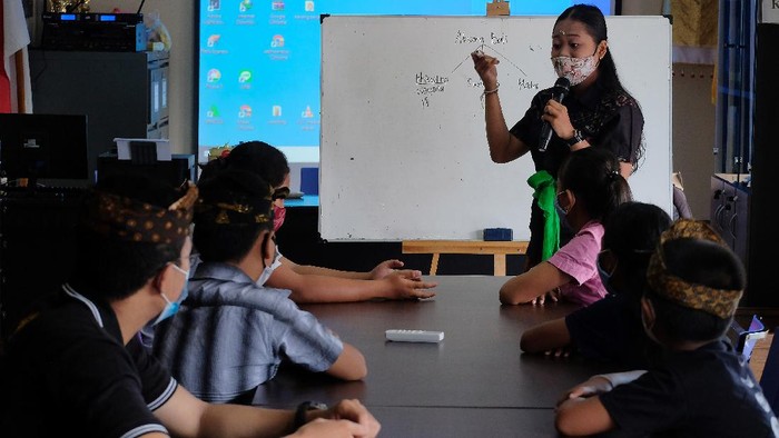 Siswa belajar secara daring dengan memanfaatkan fasilitas wifi gratis di perpustakaan desa.