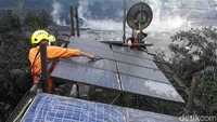 Seorang petugas terlihat membersihkan solar panel yang tertutup lumpur cukup tebal. Uje Hartono/detikcom