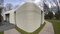View of the living room with the open kitchen showing the printer layers in the walls of the 3D-printed 94-square meters (1,011-square feet) two-bedroom bungalow resembling a boulder with windows in Eindhoven, Netherlands, Friday, April 30, 2021. The fluid, curving lines of its gray walls look natural. But they are actually at the cutting edge of housing construction in the Netherlands and around the world. They were 3D printed at a nearby factory. (AP Photo/Peter Dejong)