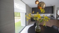 View of the living room with the open kitchen showing the printer layers in the walls of the 3D-printed 94-square meters (1,011-square feet) two-bedroom bungalow resembling a boulder with windows in Eindhoven, Netherlands, Friday, April 30, 2021. The fluid, curving lines of its gray walls look natural. But they are actually at the cutting edge of housing construction in the Netherlands and around the world. They were 3D printed at a nearby factory. (AP Photo/Peter Dejong)
