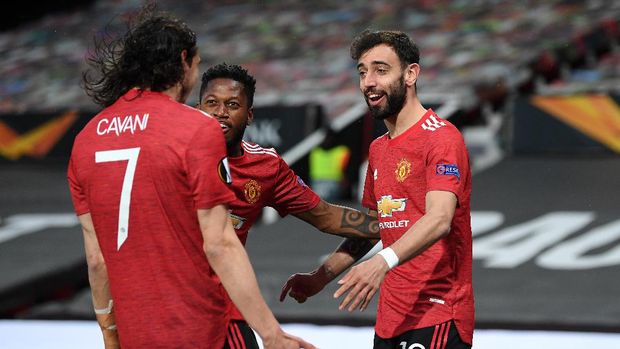 MANCHESTER, ENGLAND - APRIL 29: Bruno Fernandes of Manchester United celebrates with teammates Fred and Edinson Cavani after scoring their team's first goal during the UEFA Europa League Semi-final First Leg match between Manchester United and AS Roma at Old Trafford on April 29, 2021 in Manchester, England. Sporting stadiums around Europe remain under strict restrictions due to the Coronavirus Pandemic as Government social distancing laws prohibit fans inside venues resulting in games being played behind closed doors. (Photo by Michael Regan/Getty Images)