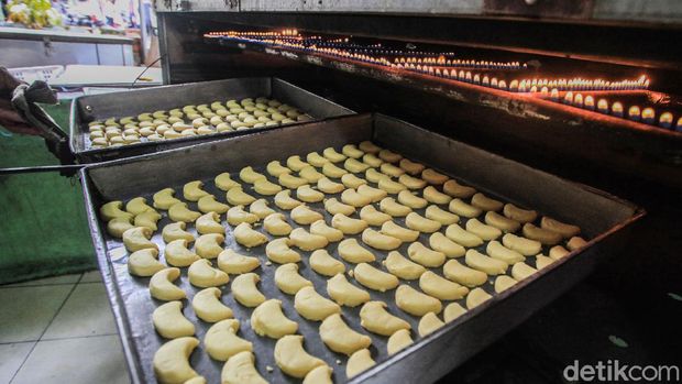 Para pekerja menyelesaikan pembuatan kue kering di 'Butter Cookies Pusaka Kwitang', Jakarta, Jumat (30/4/2021). Permintaan kue kering di pekan ketiga Ramadhan masih lesu dibandingkan masa sebelum pandemi. Pada saat belum pandemi Covid-19 atau Idul Fitri 2019, industri rumahan ini menghabiskan 2 kuintal tepung terigu per hari.