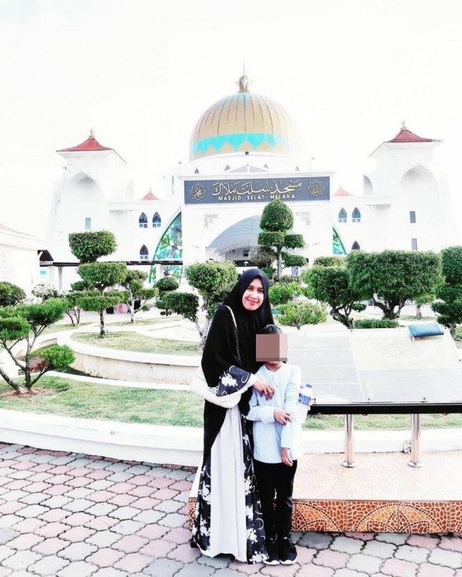 Dalam gaya hijab sehari-hari, Mellya Juniarti tampil feminin dan syari. Mellya Juniarti kerap memakai khimar dan gamis panjang. Seperti dalam foto ini, ia memakai khimar hitam dan juga gamis bernuansa floral warna hitam dan gradasi putih. Foto: Dok. Instagram @mizyanhadziq.