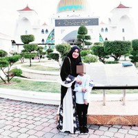 Dalam gaya hijab sehari-hari, Mellya Juniarti tampil feminin dan syari. Mellya Juniarti kerap memakai khimar dan gamis panjang. Seperti dalam foto ini, ia memakai khimar hitam dan juga gamis bernuansa floral warna hitam dan gradasi putih. Foto: Dok. Instagram @mizyanhadziq.