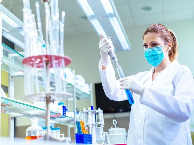 Woman in laboratory, examining new potions for the scientific research at university. Woman is wearing protective mask and protective gloves (Surgical gloves) while working with beakers, test tubes and other lab equipment. Series of images, taken with Nikon D800 and 50mm or 85 mm professional lens, developed from RAW.