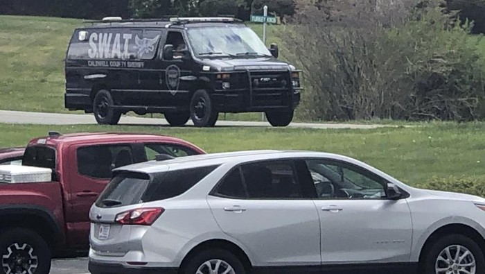 In this photo provided by WJZY, a tactical van from Caldwell County, North Carolina, sits on stand-by at a staging area in Boone, N.C., on Wednesday, April 28, 2021. Law enforcement agencies responded to a standoff in Boone in which two Watauga County sheriff’s deputies were shot and wounded. (Morgan Frances/WJZY via AP)
