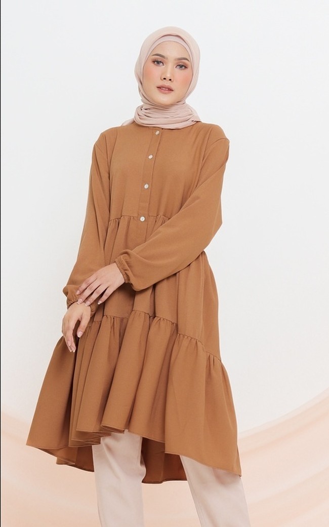 Tunik warna cokelat lain yang cantik untuk dipakai saat Lebaran datang dari Tufine.id. Kalla Top tersebut hadir dengan potongan A-line dan mullet yang membuat menarik. Item seharga Rp 188 ribuan ini bisa dengan mudah dipadukan dengan berbagai bawahan.  Foto: Dok. Hijabenka