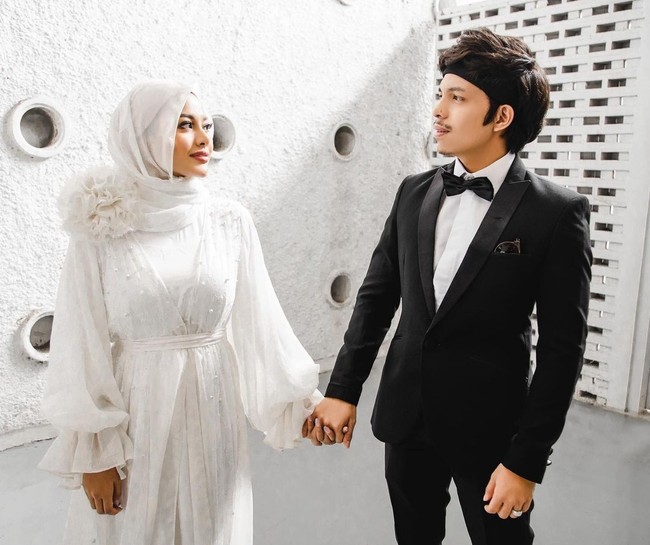 Atta Halilintar pun mengunggah foto dirinya bersama sang istri yang kini sering tampil berhijab. Bak pemotretan pre-wedding, Aurel tampak cantik berbalut gaun putih dengan hijab sifon warna senada. Foto: Instagram/@aurelie.hermansyah @attahalilintar
