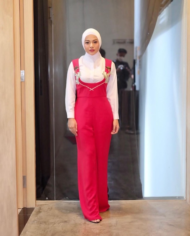 Menjalani syuting, Aurel Hermansyah tampil modis dan colorful dengan jumpsuit merah yang dipadu kemeja putih. Foto: Instagram/@aurelie.hermansyah @attahalilintar