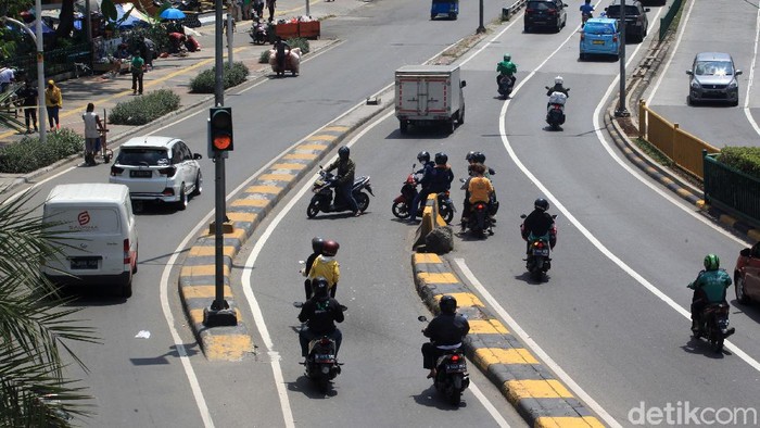 Jalan Pintas yang Berbahaya Pengendara roda dua mengambil jalan pintas dengan melawan arus di perpotongan jalan Mas Mansyur dan flyover Cideng, Tanah Abang, Sabtu (1/5/2021). Pengendara terpaksa memotong jalan untuk menyingkat waktu tempuh lantaran jalur putar balik berada setelah flyover Cideng. (ARI SAPUTRA/detikcom)