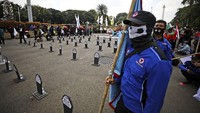 Massa buruh juga membawa beberapa nisan bertuliskan aspirasi mereka.