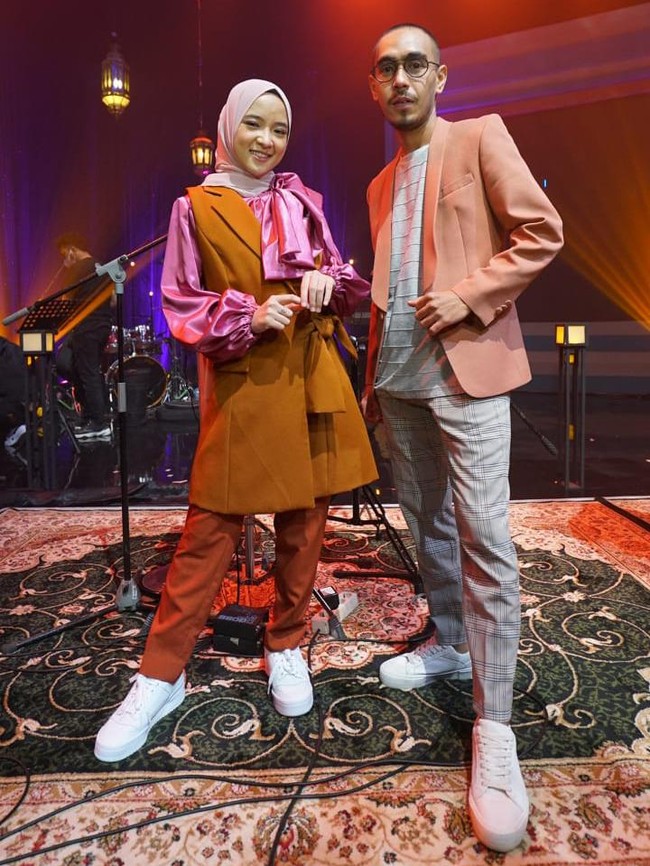 Nissa Sabyan mengenakan tiga kostum untuk mengisi acara yang digelar pada Jumat (30/4/2021). Salah satunya adalah setelan long vest yang dipadu blouse satin fuschia beraksen pita. Foto: Dok. InsertLive