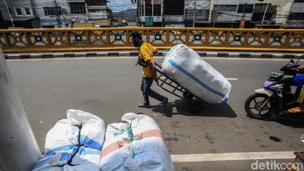 Sejumlah buruh panggul hilir-mudik di Pasar Tanah Abang, Jakarta, Sabtu (1/5/2021). Pada masa pandemi, pendapatan buruh panggul turun drastis dari menjadi sekitar Rp 100.000/hari.