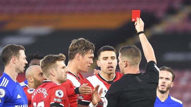 A referee Robert Jones gives red card to Southampton's Jannik Vestergaard, centre, during the English Premier League soccer match between Southampton and Leicester City at St. Mary's Stadium in Southampton, England, Friday, April 30, 2021. (Neil Hall/Pool via AP)
