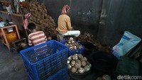 Dua pekerja tengah mengupas kelapa untuk dijadikan santan untuk membuat dodol.