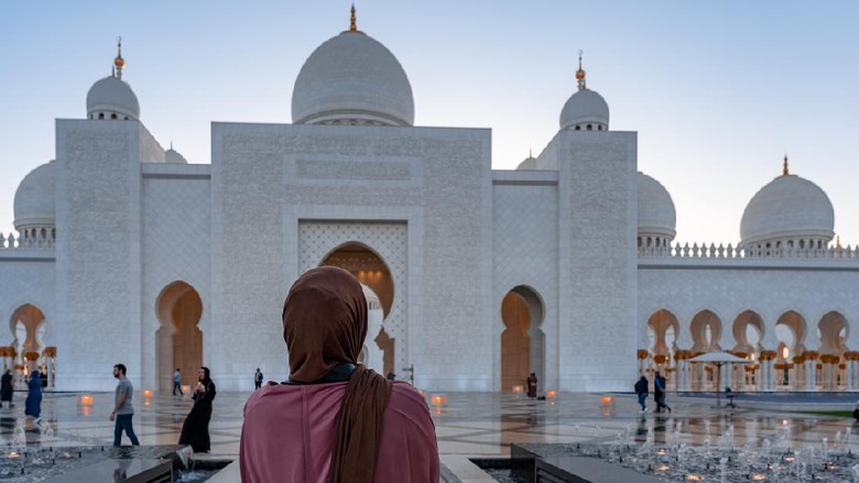 1270666620 Woman in Hijab looking at a mosque at sunset | Abu Dhabi Sheik Zayed Mosque | Beautiful islamic architecture | Tourist attraction
- Abu Dhabi, UAE, March 22, 2020