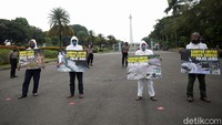 Aktivis dari lembaga Ecological Observation and Wetlands Conservation (Ecoton) menggelar aksi damai menuntut penghentian masuknya sampah import di kawasan Monumen Nasional (Monas), Jalan Merdeka Selatan, Jakarta, Senin (3/5/2021).