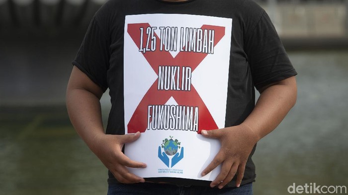 Peserta aksi memajang spanduk Tolak Pembuangan Limbah Nuklir Fukushima di Laut di Kawasan Patung Kuda, Jakarta, Senin (3/5/2021). Pembuangan limbah nuklir berpotensi menimbulkan pencemaran lingkungan laut.