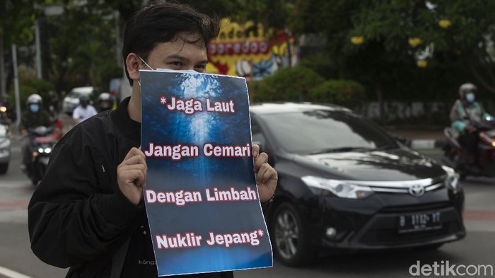 Peserta aksi memajang spanduk Tolak Pembuangan Limbah Nuklir Fukushima di Laut di Kawasan Patung Kuda, Jakarta, Senin (3/5/2021). Pembuangan limbah nuklir berpotensi menimbulkan pencemaran lingkungan laut.