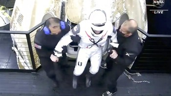 Astronaut yang agak lemah kondisinya dibantu keluar. Foto: AP