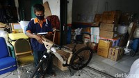 Pekerja menmbungkus sepeda yang akan dikirimkan lewat kereta api.