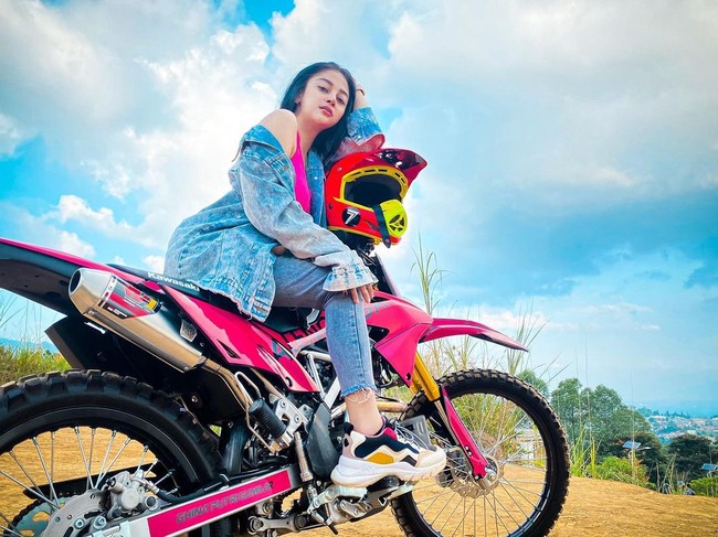 Dalam berbagai postingan, Ghina kerap berpose dengan motor trail-nya yang berwarna pink. Ia pun kerap tampil serba pink dengan jaket dan helm bernuansa serupa. Foto: Instagram @ghinakamillaa