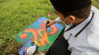 Seorang santri tengah membuat kaligrafi.
