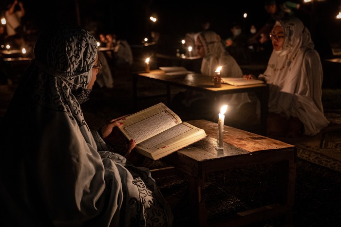 BOYOLALI, INDONESIA - MAY 02: A student prays after read the Quran by candlelight during ritual Nuzulul Quran and Laylat al-Qadr (Night of Destiny) which marks the night in which the holy Quran was first revealed to the Prophet Mohammed at the Nurul Hidayah Al-Mubarokah boarding school on May 2, 2021 in Boyolali, Central Java, Indonesia. Laylat al-Qadr is was one of the odd-numbered nights of the last ten days of Ramadan. Ramadan, the ninth month of the Islamic calendar is a month of fasting, prayers and recitation of the Quran. (Photo by Ulet Ifansasti/Getty Images)