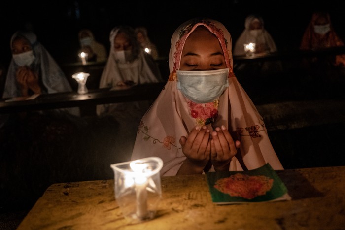 BOYOLALI, INDONESIA - MAY 02: A student prays after read the Quran by candlelight during ritual Nuzulul Quran and Laylat al-Qadr (Night of Destiny) which marks the night in which the holy Quran was first revealed to the Prophet Mohammed at the Nurul Hidayah Al-Mubarokah boarding school on May 2, 2021 in Boyolali, Central Java, Indonesia. Laylat al-Qadr is was one of the odd-numbered nights of the last ten days of Ramadan. Ramadan, the ninth month of the Islamic calendar is a month of fasting, prayers and recitation of the Quran. (Photo by Ulet Ifansasti/Getty Images)