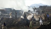 Warga melihat truk tangki bensin yang terbakar di Kabul, Afghanistan, Minggu (2/5/2021) waktu setempat.  