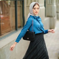 Influencer yang mengawali karier sebagai model ini juga menampilkan gaya chic yang kental nuansa urban. Kali ini Anissa Aziza memadukan blouse biru dan rok tutu, serta kerudung abu-abu. Foto: Instagram/@anissaaziza, @ayubyayulestariofficial