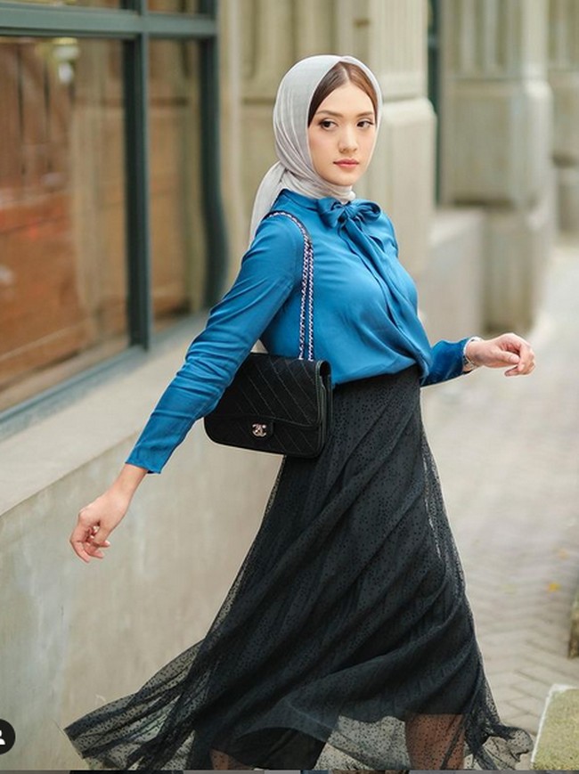 Influencer yang mengawali karier sebagai model ini juga menampilkan gaya chic yang kental nuansa urban. Kali ini Anissa Aziza memadukan blouse biru dan rok tutu, serta kerudung abu-abu. Foto: Instagram/@anissaaziza, @ayubyayulestariofficial