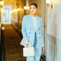 Anissa Aziza tampak elegan dengan gaya monokrom biru muda pada setelan busananya. Kerudung warna oranye yang kontras dengan busana memberi kesan cerah. Foto: Instagram/@anissaaziza, @ayubyayulestariofficial