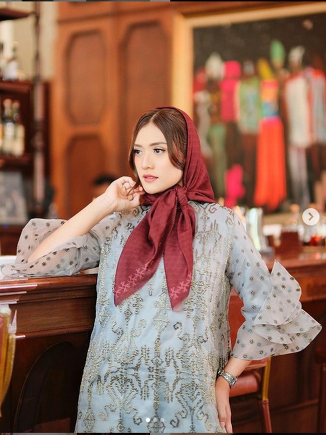 Mengenakan gaun abu-abu dan scarf marun, gaya Anissa Aziza satu ini bisa jadi inspirasi kamu berbusana di Hari Raya. Foto: Instagram/@anissaaziza, @ayubyayulestariofficial