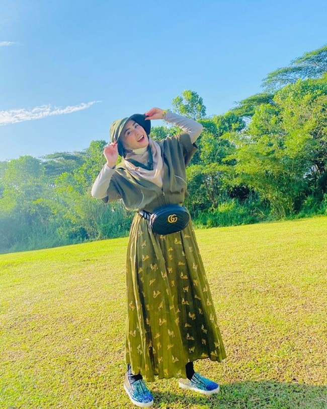 Liburan ke Taman Safari bersama Ustaz Solmed dan ketiga anak mereka, April Jasmine bergaya #ootd dengan long dress hijau dan belt bag dari brand Gucci. Foto: Dok. Instagram @apriljasmine85