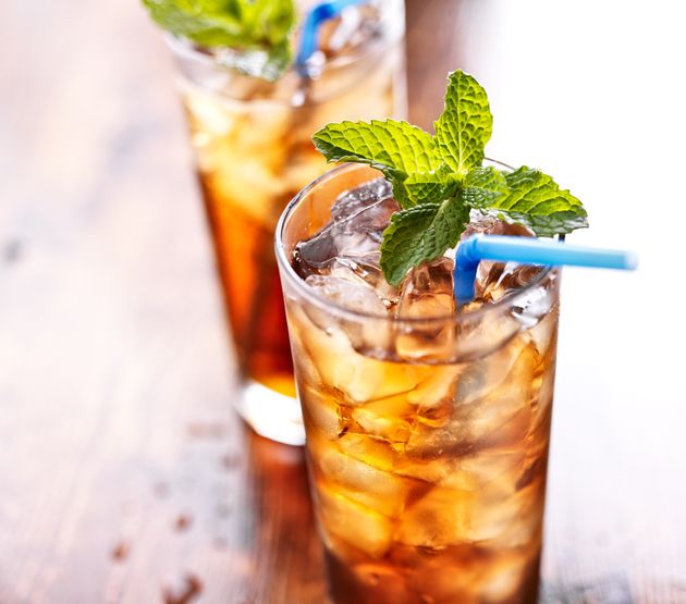 iced tea with blue straw and mint garnish , shot with selective focus.
