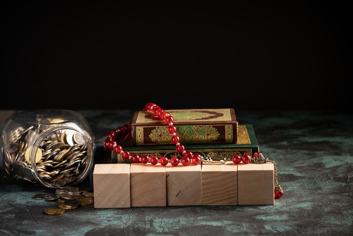 Islamic concept: The holy Quran and Tasbih (rosary beads) on dark background