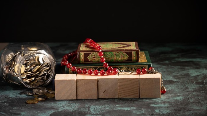 Islamic concept: The holy Quran and Tasbih (rosary beads) on dark background
